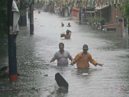 Residents wade through a flooded street in Manila following heavy rains brought about by typhoon Fengshen Sunday, June 22, 2008 in Manila. Typhoon Fengshen lashed across the Philippines for a second day Sunday, killing at least 80 people as it submerged entire communities and capsized a passenger ferry carrying more than 700 passengers and crew. (AP Photo/Bullit Marquez)